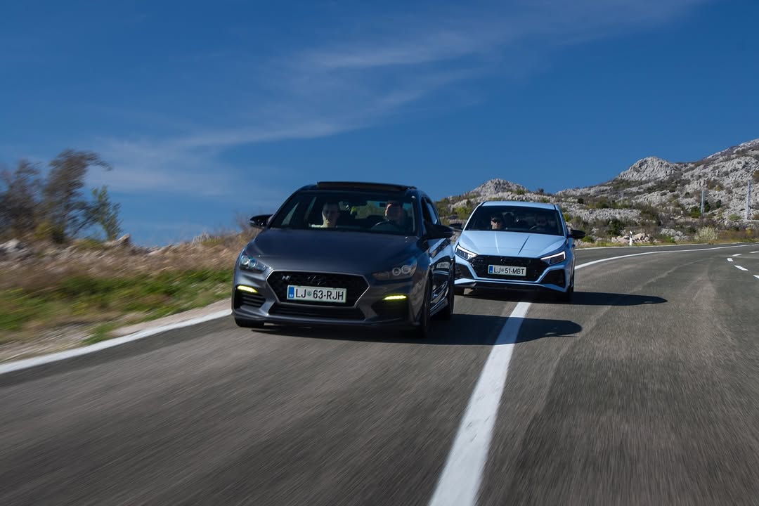 Dva Hyundai i30 N v vožnji po obalni cesti