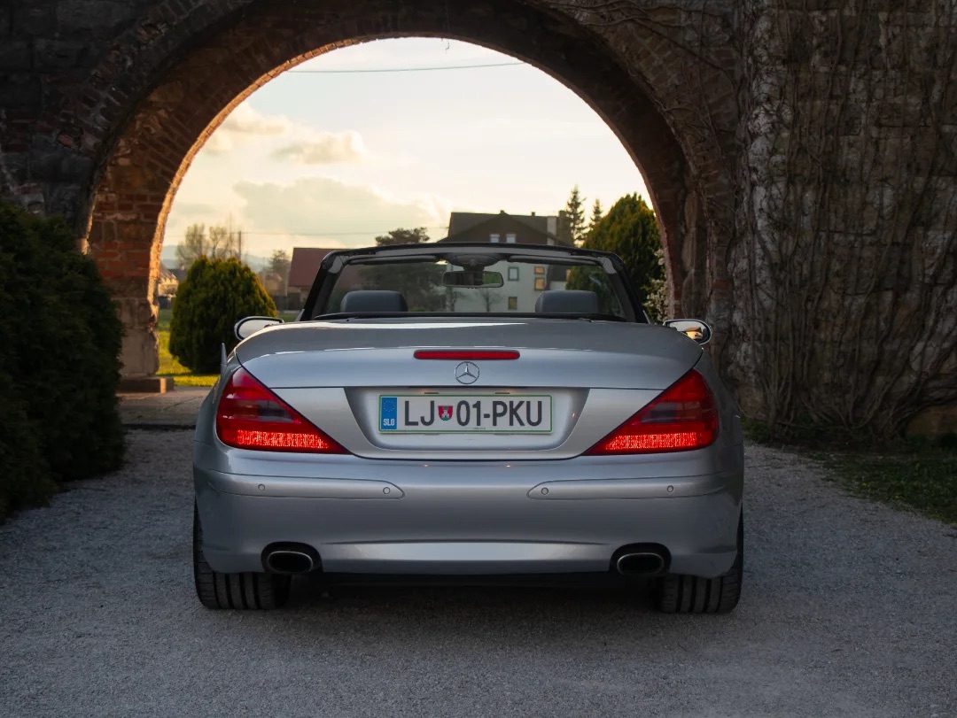 Srebrn Mercedes SL pod kamnitim lokom ob zahodu